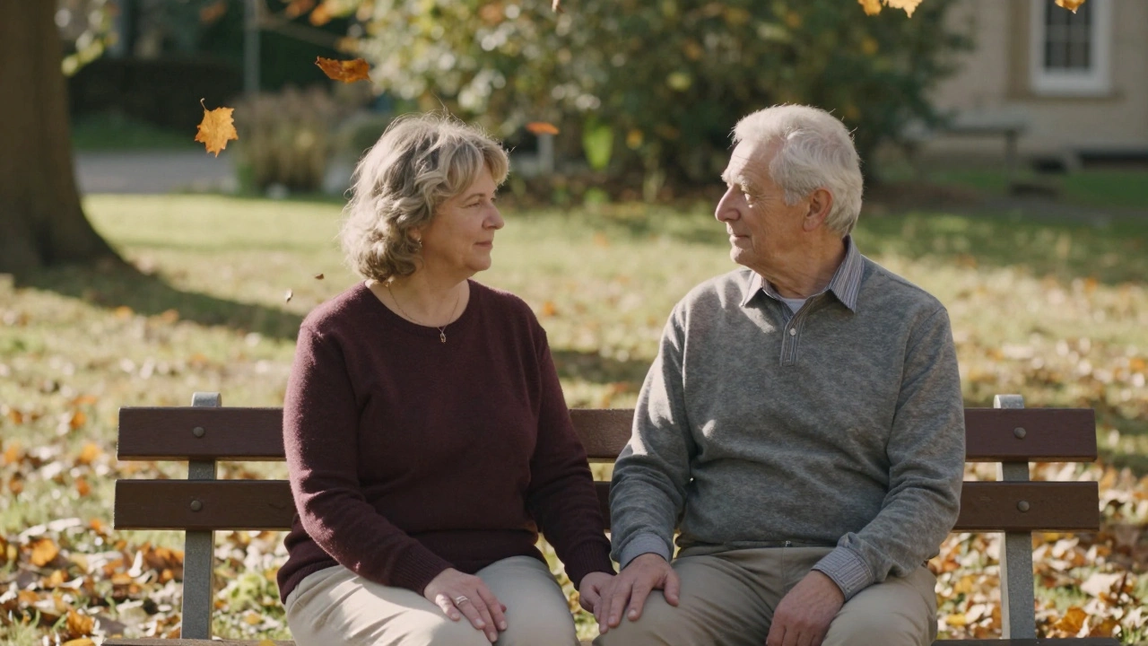 Dvojice sedí na lavičce v zahradě, ruce se jen dotýkají, listy padají, klidná atmosféra.