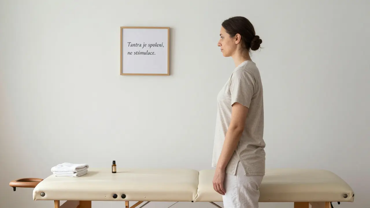 Profesionální masér stojí vedle čisté masážní lůžky v prostorém, přirozeně osvětleném prostředí.