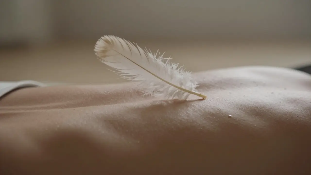 Detail pštrosího peří jemně dotýkající se kůže pro probuzení smyslů.